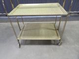 a metal table with a basket on top of it