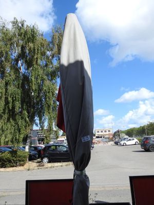 deux ordinateurs portables posés sur une table devant un parasol