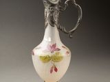 un vase blanc avec des fleurs roses sur une table