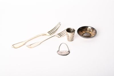 une cuillère, une fourchette et un repose-cuillère posés sur une surface blanche