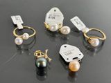 three pairs of pearl and gold rings with price tags on them
