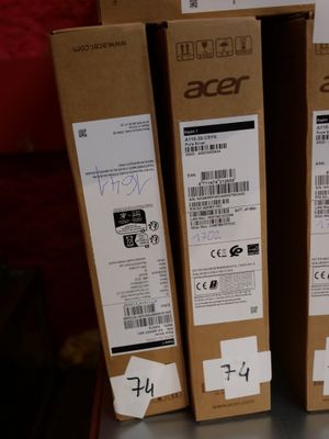 Trois boîtes de produits Acer sont posées sur une étagère dans un magasin