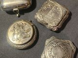 three silver lockes and a silver case on a black surface