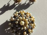 two pairs of earrings and a broochet on a white surface
