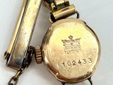a close up of a watch with a chain attached to it