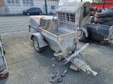 un camion équipé d'une cage à l'arrière, garé à côté d'autres camions