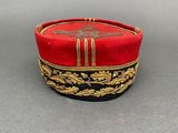 an image of a red hat with gold trim and a cross on it