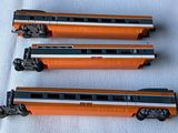 three toy trains that are sitting on a white surface