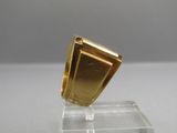 une bague en or posée sur un socle transparent
