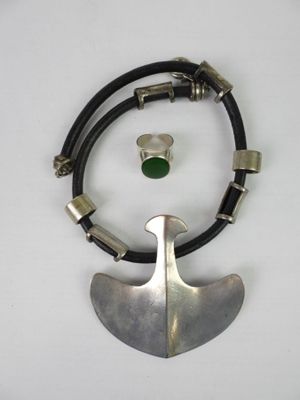 silver and green necklace with a leather cord and a silver pendant with a green stone on it