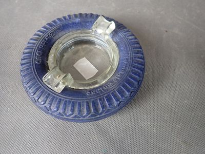 un cendrier en verre bleu contenant un morceau de papier carré