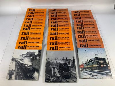 Plusieurs magazines sont posés sur une table, avec un train en arrière-plan.