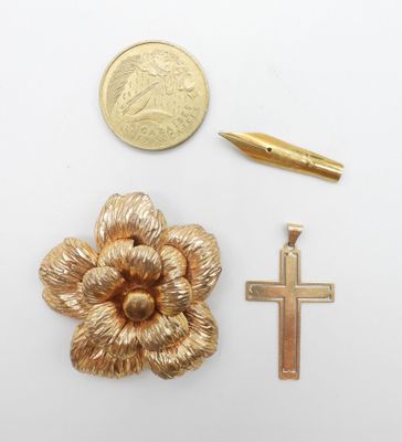an image of a cross, a pen, and a gold flower brooch