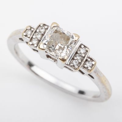 a white gold ring with a diamond and three small diamonds