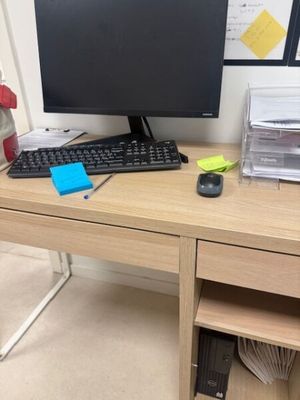 a desk with a computer, keyboard, mouse, and other items on it
