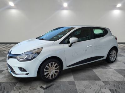 une voiture blanche garée dans un garage au sol en damier