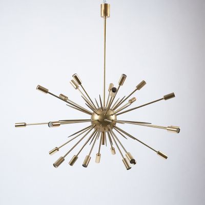 un grand lustre en laiton à huit lumières suspendu au plafond
