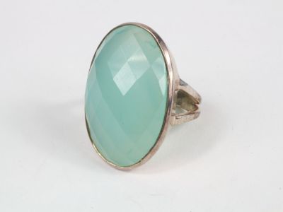 Gros plan sur une bague ornée d'une pierre verte