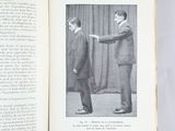 an open book with a picture of a man shaking another man ' s hand
