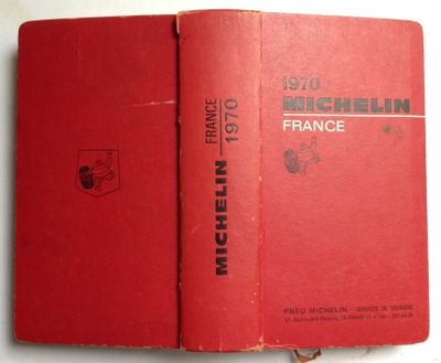 an old red book sitting on top of a white table