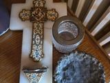 une croix, un bougeoir et un bol posés sur une table