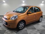 une photo d'une petite voiture orange garée dans un garage