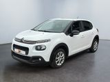 Une Citroën blanche est garée dans une pièce blanche