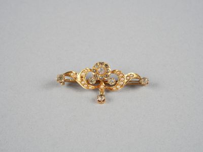 un gros plan sur une broche en or sertie de diamants