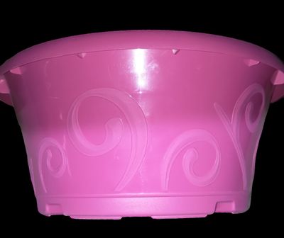 un récipient en plastique rose orné de motifs en spirale