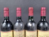 four bottles of wine are lined up on a table