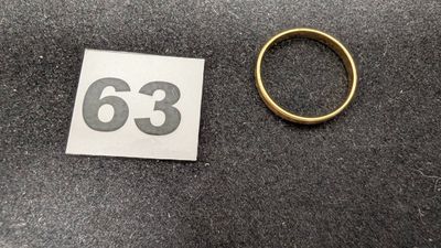 une photo d'une bague et d'un autocollant posés sur une table