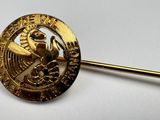 a gold pin with a picture of a horse on it