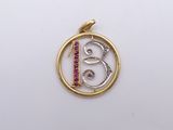 a close up of a gold and silver pendant with a bird on it
