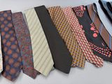 several different colored ties are lined up on a white surface