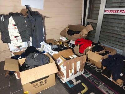 de nombreux cartons de vêtements posés sur le sol devant une porte