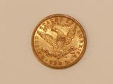 a close up of a gold coin on a white surface