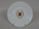 une assiette blanche ornée d'un motif doré et rouge