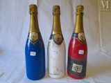 three bottles of wine are lined up on a white surface