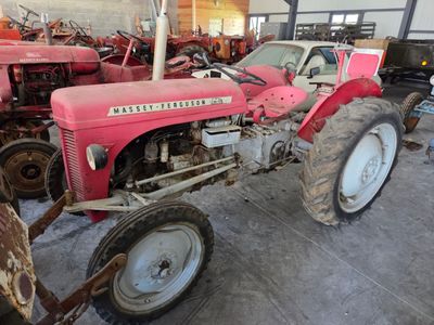 a red tractor that is parked inside of a building