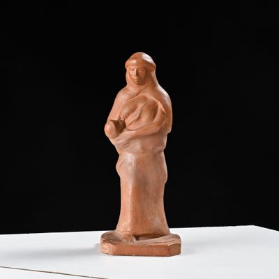 sculpture représentant une femme tenant un enfant dans ses bras, posée sur une surface blanche