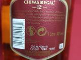 bottle of chivas regall 12 year old whisky on a pink table