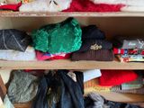a wooden shelf filled with lots of sweaters and scarves