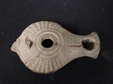 an old metal object on a black surface with a hole in the middle