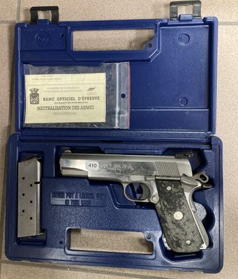 une mallette bleue contenant un pistolet, posée sur une table