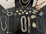 many different types of necklaces and bracelets laid out on a table