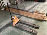 un chariot élévateur posé sur une palette dans un entrepôt