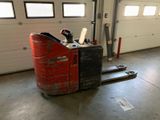 un chariot élévateur dans un garage, avec des fenêtres en arrière-plan