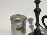 a silver candle holder and a canister on a table