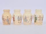 four small vases with pictures of people on them sitting on a white surface