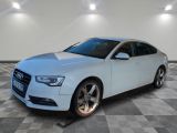 une Audi blanche garée dans une grande pièce au sol carrelé